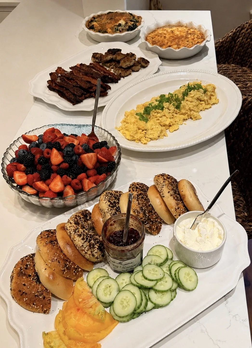 A brunch spread with bagels, berries, eggs, and savory dishes
